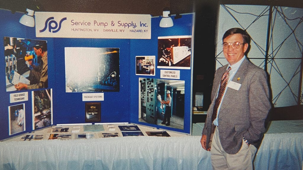 Photo: Dave Crabtree, founder of SPS's municipal solutions division, poses in front of a Service Pump trade show booth circa 1985. 